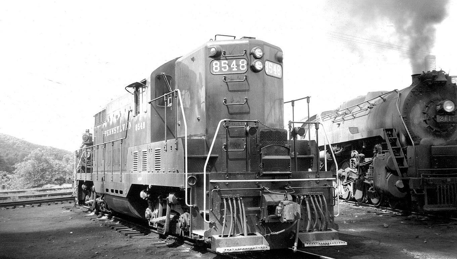 Pennsylvania Railroad GP7 No. 8548 probably in August 1955 in Baltimore, Maryland. Next to her is Reading Co. Class T-1 No. 2117.