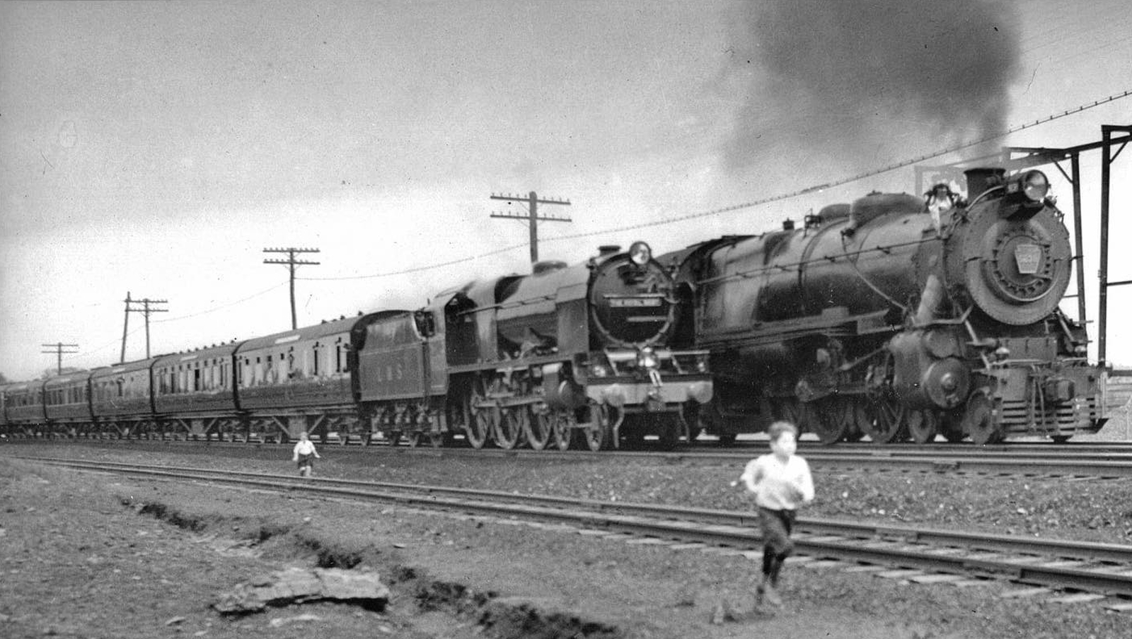 No. 6152 “The King's Dragoon Guardsman” with the nameplate of No. 6100 “Royal Scot” and US-qualified headlight and bell on her US tour alongside a Pennsylvania Railroad K4s