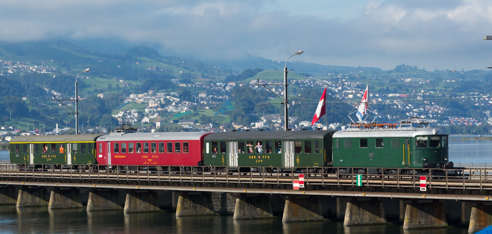 Re 4/4 I 10044 of the SBB Historic with a train made of light steel wagons on the Seedamm between Pfäffikon and Rapperswil in September 2013